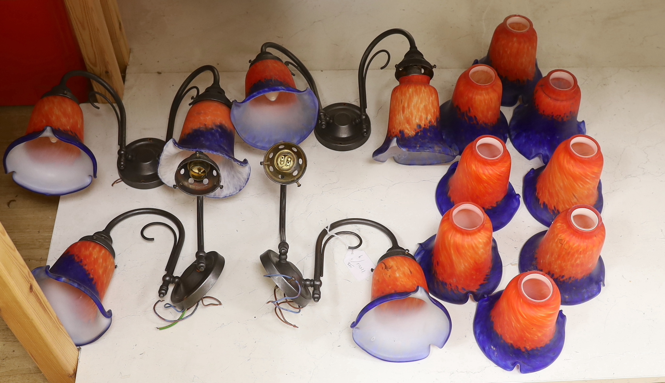 Four two branch metal wall lights with orange and blue glass shades and a set of six matching shades